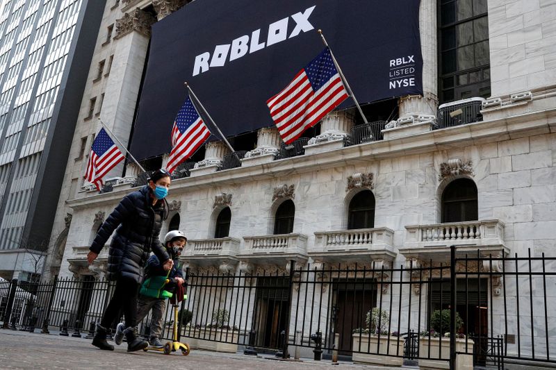 &copy; Reuters. Gente pasa frente a la fachada de la Bolsa de Nueva York con un cartel anunciado la OPI de la firma Roblox.