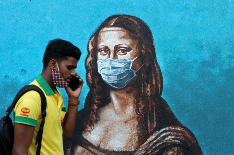 © Reuters. A man walks past a mural depicting the 