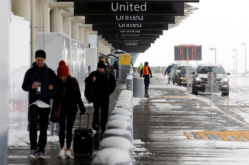 &copy; Reuters. FILE PHOTO: Travelers walk past the United check-in area after a snowstorm at Denver International Airport