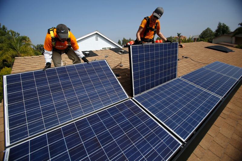 &copy; Reuters. Técnicos instalam painéis de energia solar no telhado de uma residência; sistemas como esses, de geração distribuída, têm crescido em ritmo acelerado no Brasil