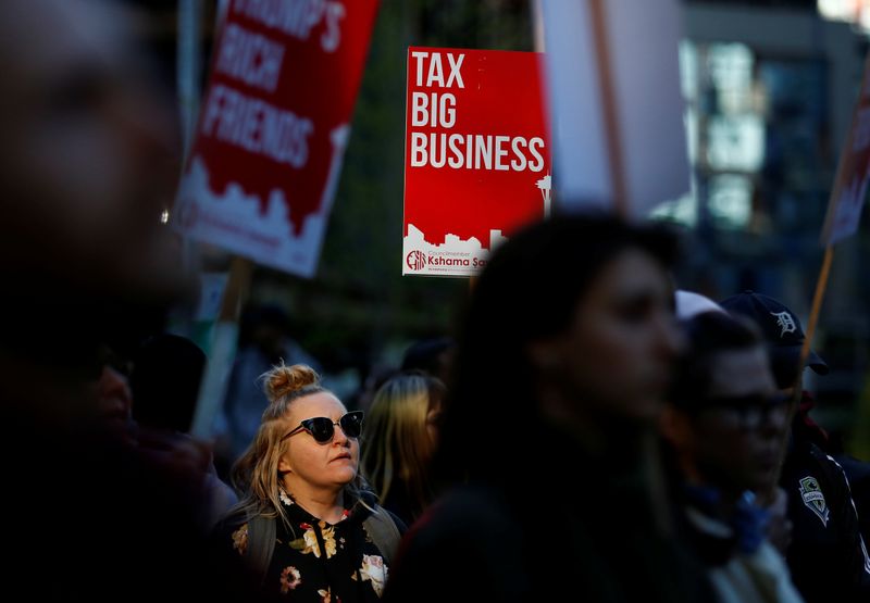&copy; Reuters. A woman holds a sign during a protest outside the Amazon Spheres to demand that the city of Seattle tax the largest corporations to help fund affordable housing in Seattle