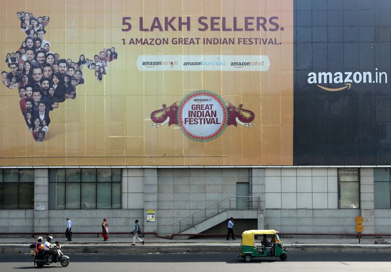 © Reuters. FILE PHOTO: People move past a hoarding of Amazon India outside a metro rail station in New Delhi,