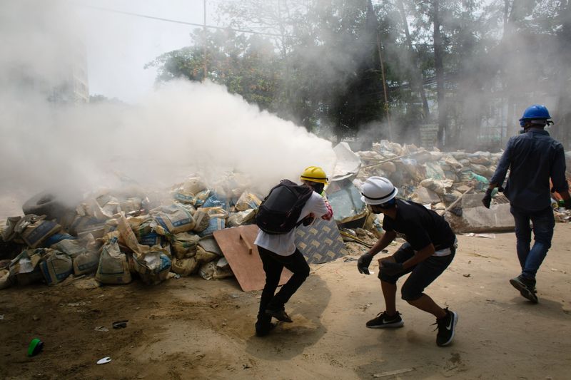 © Reuters. Protesters use fire extinguishers during a protest against the military coup in Yangon