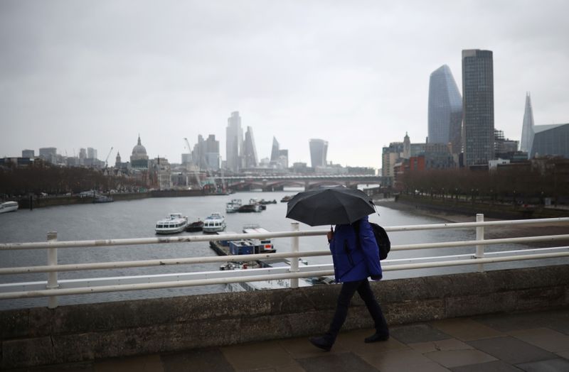 &copy; Reuters. A woman holding an umbrella walks over Waterloo Bridge during rainfall, amid the coronavirus disease (COVID-19) outbreak, in London