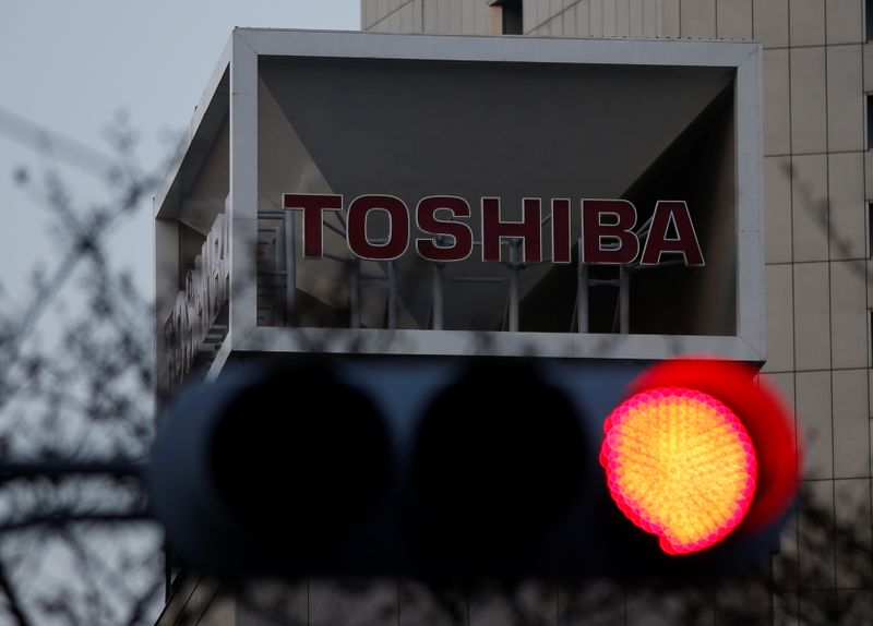 © Reuters. The logo of Toshiba Corp is seen behind a traffic light at the company's headquarters in Tokyo