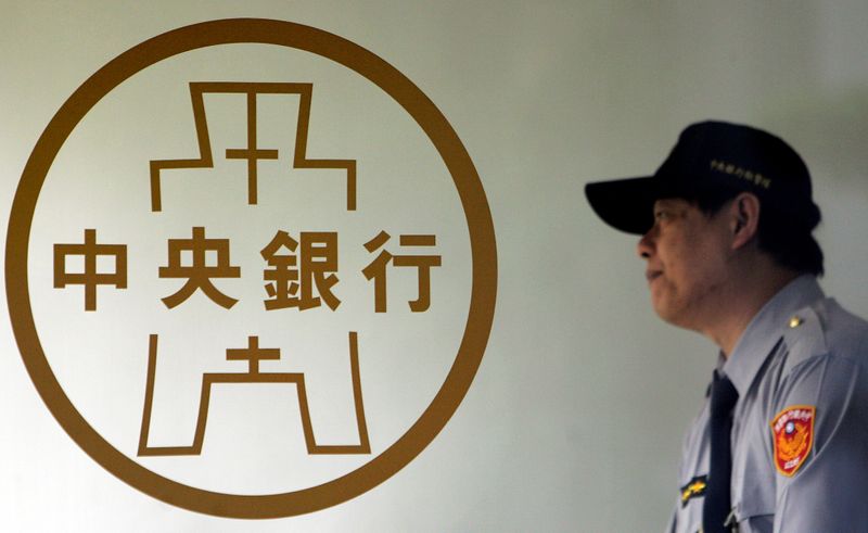 &copy; Reuters. A police officer stands beside the Taiwan Central Bank logo in Taipei