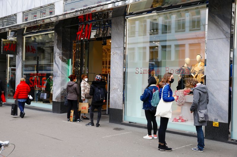 &copy; Reuters. FOTO DE ARCHIVO: Varias personas con mascarilla esperan en el exterior de una tienda de H&amp;M en Zúrich