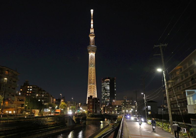 © Reuters. The Tokyo Skytree is illuminated with the color of the Olympic Torch to mark 100 days until the start of torch relay for the postponed Olympics