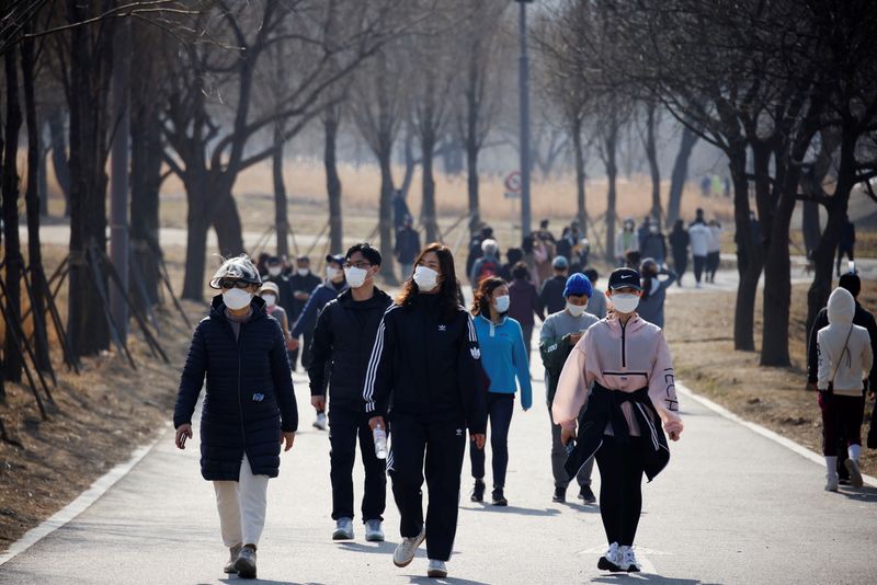 &copy; Reuters. Personas con máscaras dan un paseo durante la epidemia de coronavirus (COVID-19) en un parque de Hanriver en Seúl