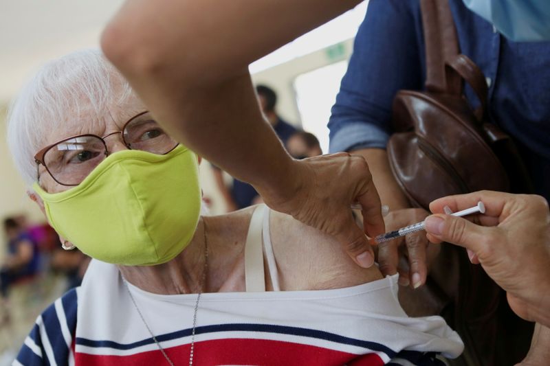 &copy; Reuters. Imagen de archivo. Una mujer recibe la primera dosis de la vacuna contra el COVID-19 de Pfizer-BioNTech en San José