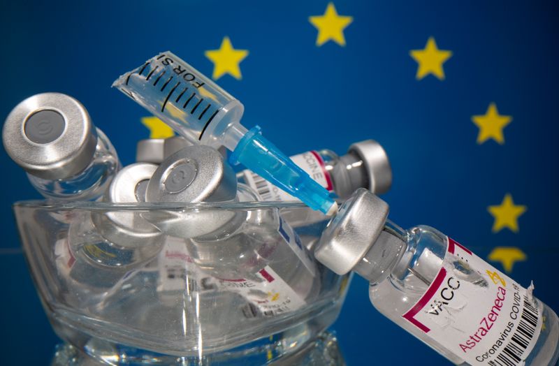 &copy; Reuters. Vials labelled with broken sticker &quot;AstraZeneca COVID-19 Coronavirus Vaccine&quot; and a broken syringe are seen in front of a displayed EU flag in this illustration