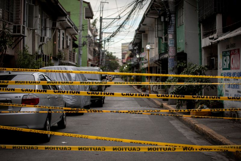 &copy; Reuters. FOTO DE ARCHIVO: Cintas de plástico cruzadas en una calle bajo confinamiento por la pandemia de COVID-19 en Manila