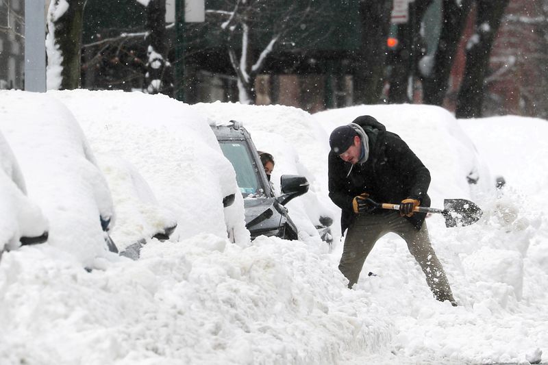 &copy; Reuters. FILE PHOTO: Man digs out a car from deep snow in Manhattan after a winter storm in New York