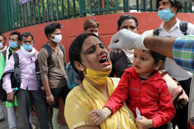 &copy; Reuters. Un trabajador sanitario realiza un hisopado a una mujer en medio de la pandemia de COVID-19, en una estación de autobús, en Nueva Delhi