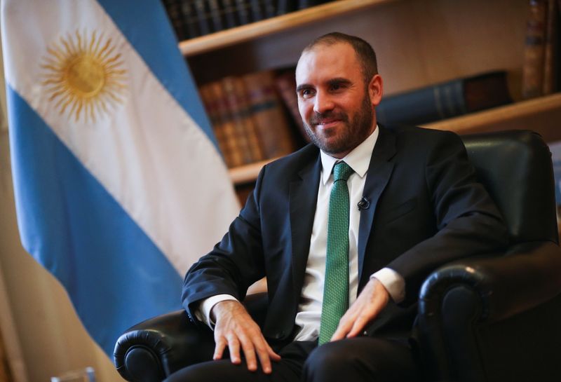 &copy; Reuters. El ministro de Economía argentino, Martín Guzmán, posa junto a una bandera nacional durante una entrevista con Reuters en su oficina en Buenos Aires