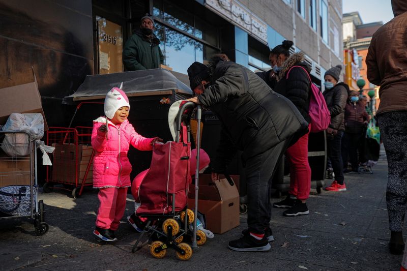 © Reuters. A child reacts as she helps to load a cart after receiving a holiday box of food from the Food Bank For New York City ahead of the Thanksgiving holiday in New York