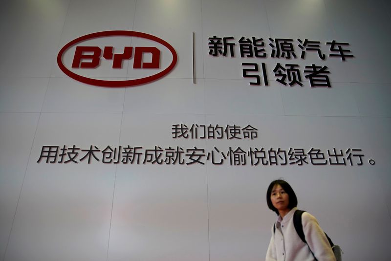 &copy; Reuters. Woman walks past a BYD sign at the second media day for the Shanghai auto show in Shanghai