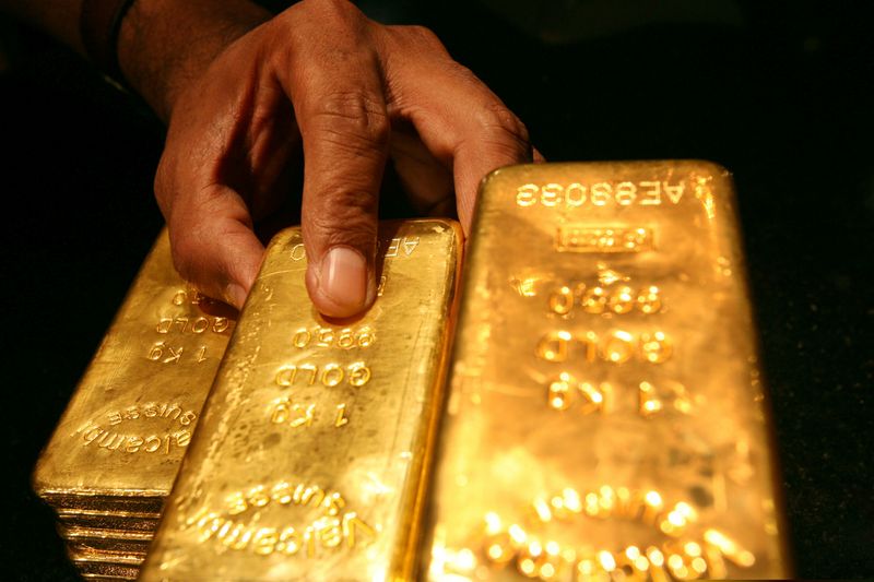 &copy; Reuters. FILE PHOTO: A security guard places several one kilo gold bars inside a secured vault in Dubai