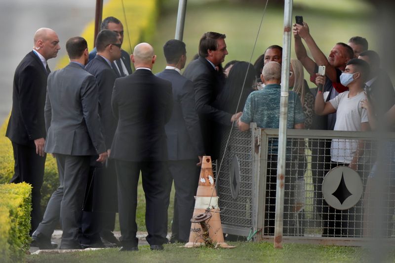 &copy; Reuters. Presidente Jair Bolsonaro conversa com apoiadores na entrada do Palácio da Alvorada