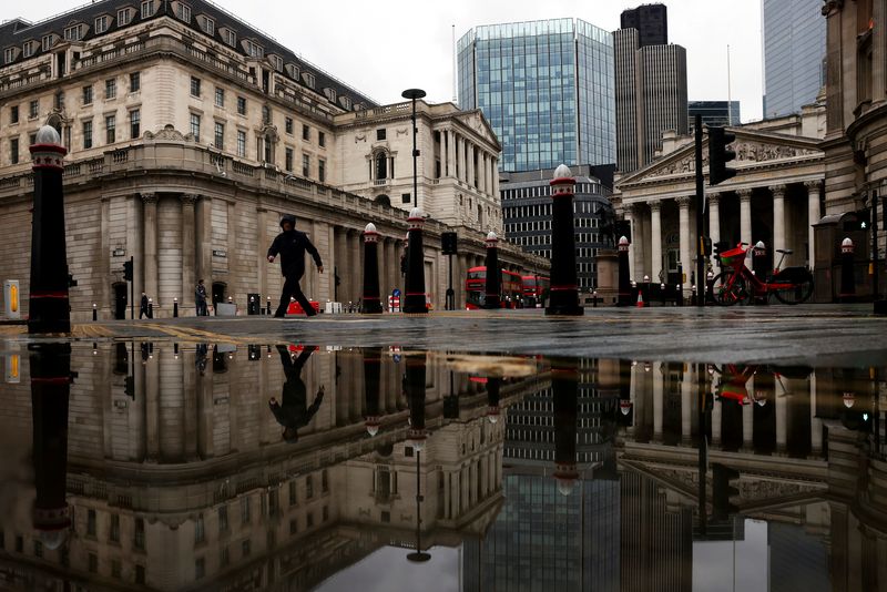 &copy; Reuters. FILE PHOTO: The Bank of England and Royal Exchange are reflected in a puddle as a pedestrian walks past in London