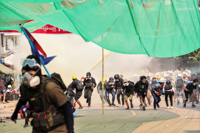 &copy; Reuters. Protesters run during a crackdown of an anti-coup protests at Hlaing Township in Yangon, Myanmar