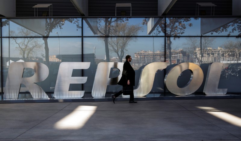 &copy; Reuters. FOTO DE ARCHIVO: Un hombre pasa junto al logotipo de la empresa en la sede de Repsol en Madrid el 16 de diciembre de 2014