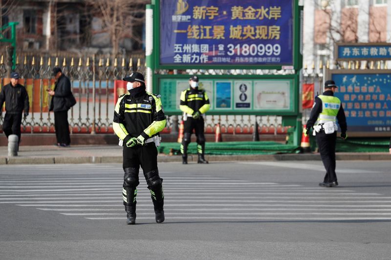 © Reuters. Police officers stand guard and control the traffic outside the Intermediate People's Court in Dandong, Liaoning, China