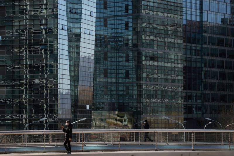 &copy; Reuters. FILE PHOTO: People wearing face masks walk on an overpass, as the country is hit by an outbreak of the novel coronavirus, in Beijing&apos;s tech hub Zhongguancun