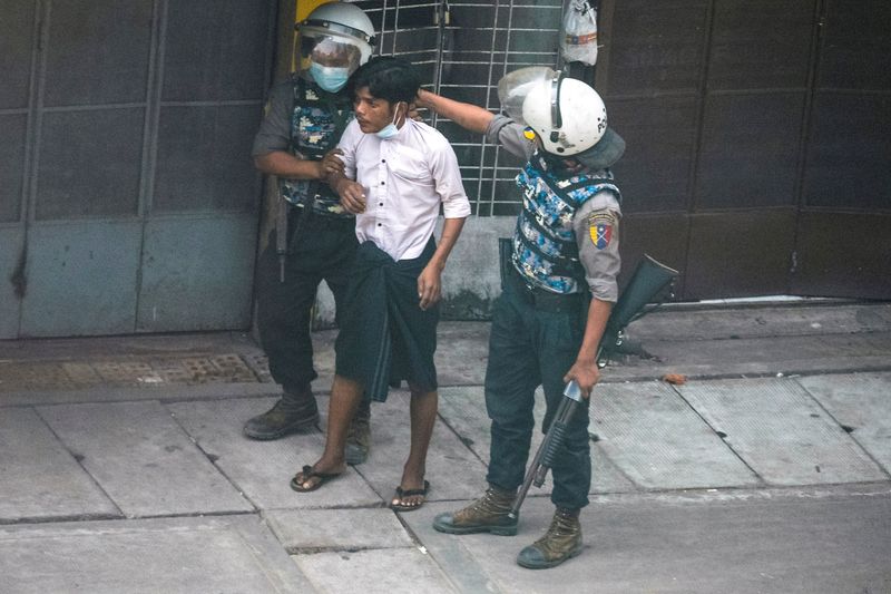 © Reuters. Riot police officers detain a demonstrator during a protest against the military coup in Yangon