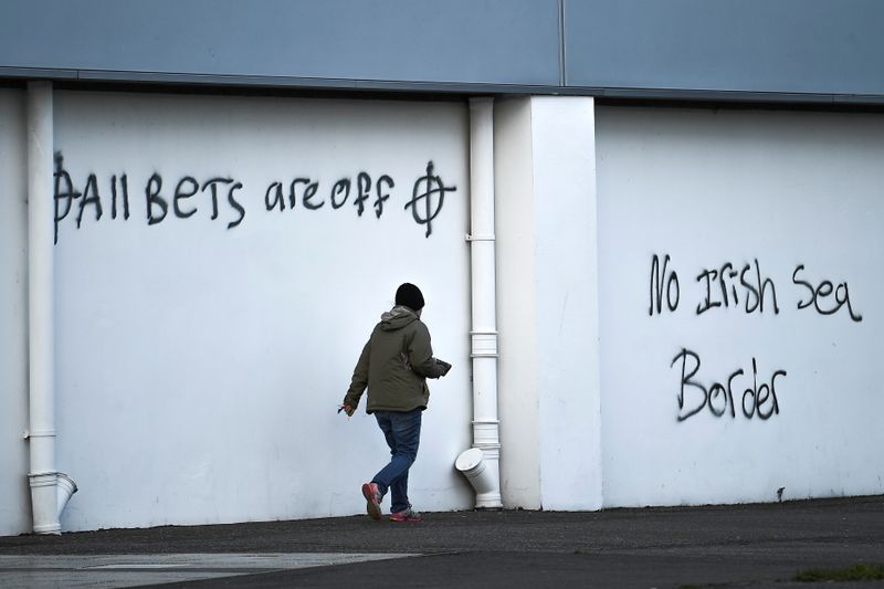 © Reuters. Loyalist graffitis are seen with messages against the Brexit border checks in relation to the Northern Ireland protocol at the harbour in Larne