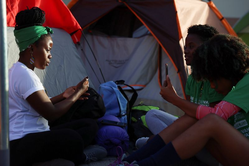 &copy; Reuters. Abortion rights activists sit outside tents set up in front of the National Palace during a protest to pressure parliament over a proposed reform to the penal code that could end the total ban on abortion, in Santo Domingo