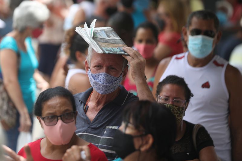 &copy; Reuters. Foto de archivo. Personas utilizando mascarillas hacen fila para recibir la primera dosis de la vacuna CoronaVac contral el COVID-19, en Duque de Caxias, estado de Río de Janeiro, Brasil