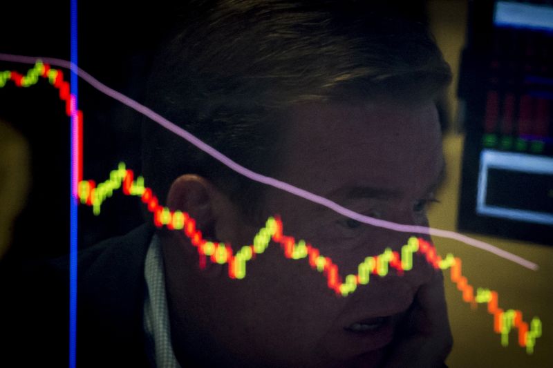 © Reuters. FILE PHOTO: A specialist trader is reflected in a screen at his post on the floor of the New York Stock Exchange