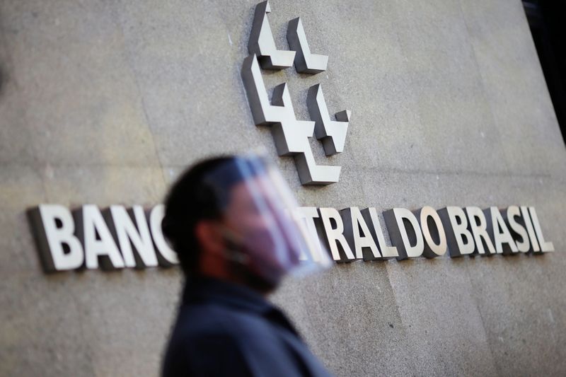 &copy; Reuters. Homem usa máscara e proteção para o rosto em frente ao Banco Central, em Brasília