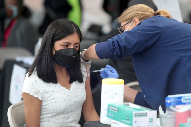 &copy; Reuters. FILE PHOTO: A woman receives a coronavirus disease (COVID-19) vaccination, at Jordan Downs in Los Angeles