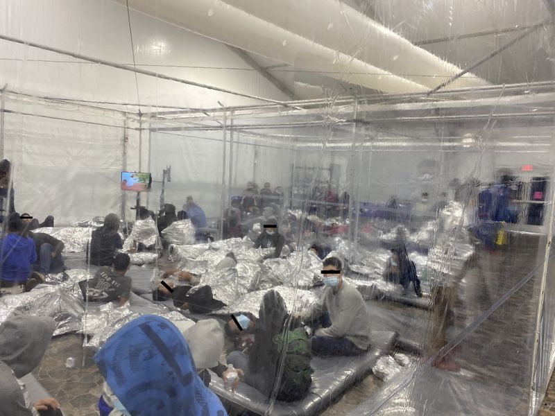 © Reuters. Migrants crowd a room with walls of plastic sheeting at the U.S. Customs and Border Protection temporary processing center in Donna