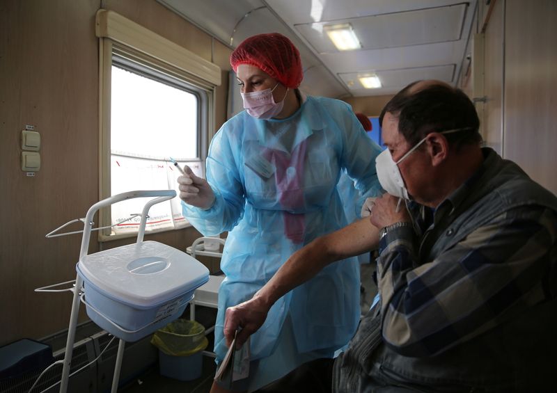 &copy; Reuters. A man receives a dose of COVID-19 vaccine in a medical train in Tulun