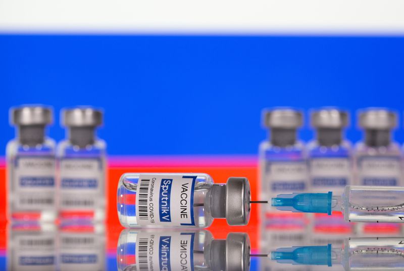 &copy; Reuters. Vials labelled &quot;Sputnik V Coronavirus COVID-19 Vaccine&quot; and a syringe are seen in front of a displayed Russian flag, in this illustration photo