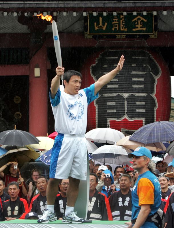 © Reuters. OLYMPIC JUDO GOLD MEDALIST JAPAN'S TOSHIHIKO KOGA HOLDS OLYMPIC TORCH AT SENSOJI TEMPLE IN TOKYO.