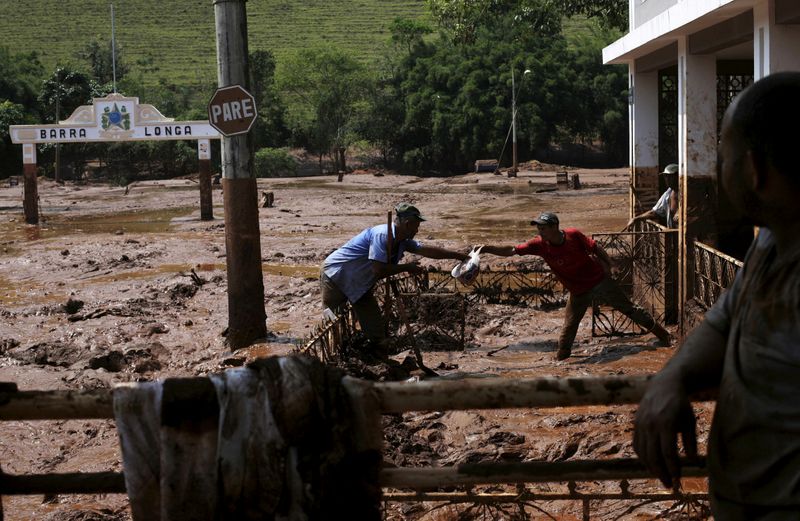&copy; Reuters. FILE PHOTO: Men take out a bag from a house flooded with mud after a dam owned by Vale SA and BHP Billiton Ltd burst, in Barra Longa