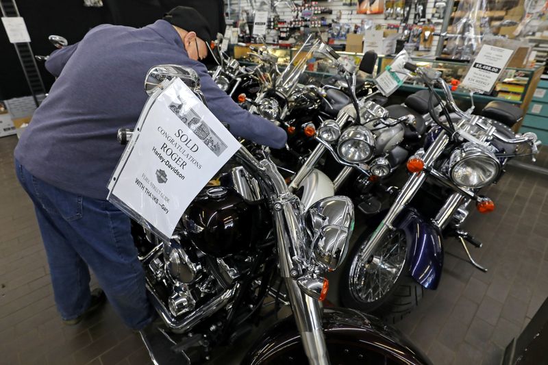 © Reuters. Gary Haines places a SOLD sign on a Harley Davidson motorcycle in Toronto