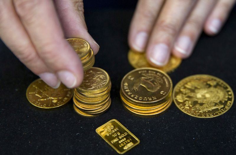 &copy; Reuters. FILE PHOTO: A worker places gold bullion on display at Hatton Garden Metals precious metal dealers in London