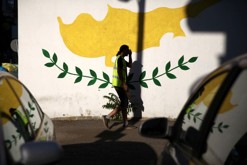 &copy; Reuters. A man walks past a Cypriot flag painted on a wall in Nicosia