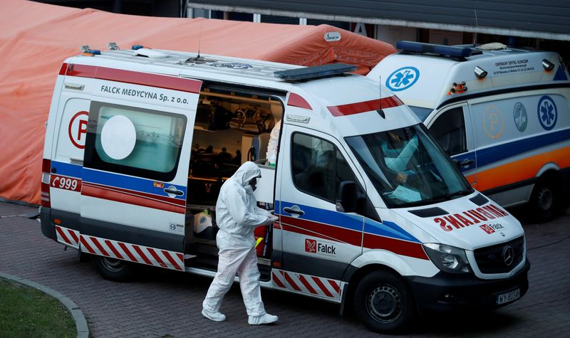 © Reuters. FILE PHOTO: A paramedic walks near an ambulance amid the coronavirus disease (COVID-19) outbreak, in front of a hospital in Warsaw