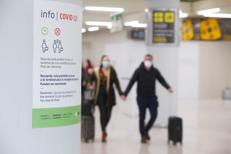 &copy; Reuters. FOTO DE ARCHIVO: Un cartel informativo sobre las normas de actuación frente a la COVID-19 en el aeropuerto de Palma de Mallorca