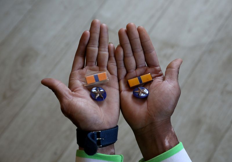 &copy; Reuters. FILE PHOTO: A Myanmar national who said he was a policeman and recently fled to India shows his badges as he poses at an undisclosed location