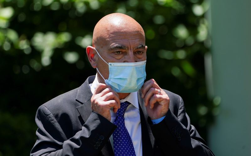 &copy; Reuters. FILE PHOTO: Moncef Slaoui adjusts his protective face mask after speaking at a coronavirus disease response event in the Rose Garden at the White House in Washington