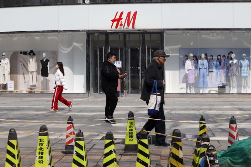&copy; Reuters. Varias personas caminan frente a una tienda del grupo sueco H&amp;M en un complejo comercial en Pekín