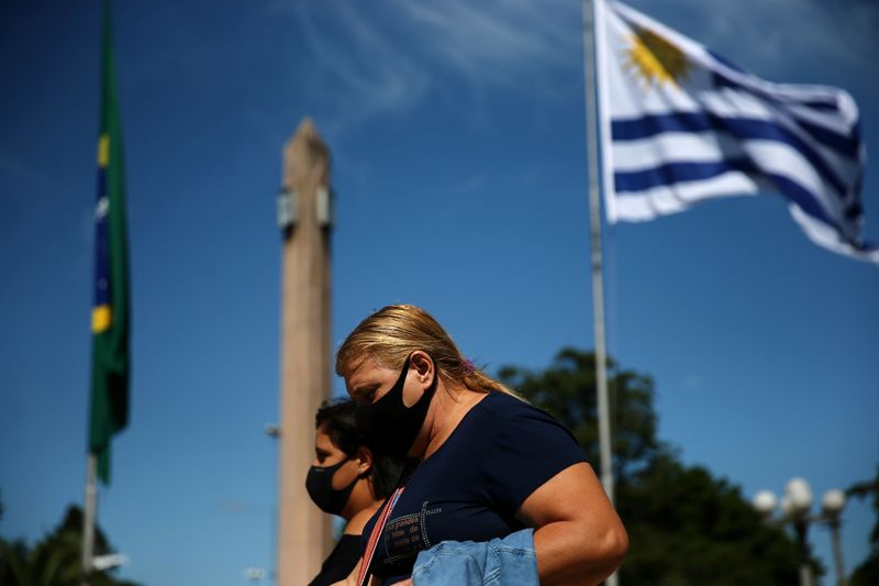 &copy; Reuters. Mulher caminha na fronteira entre Brasil e Uruguai, em Santana do Livramento, no lado brasileiro, e em Rivera, no lado uruguaio, em meio a temores com a pandemia de Covid-19 no Brasil