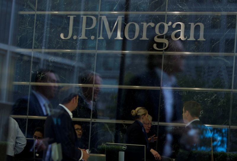 © Reuters. FILE PHOTO: Workers are reflected in the windows of the Canary Wharf offices of JP Morgan in London